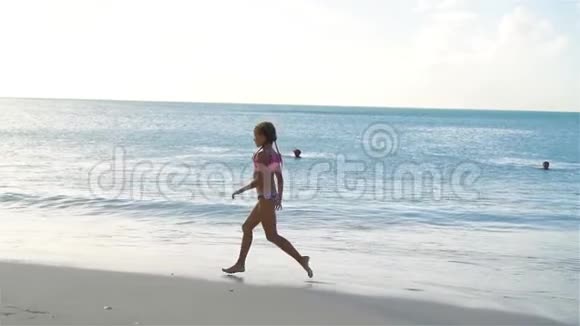 小女孩在白色海滩上做运动海滨体操流动人口视频的预览图