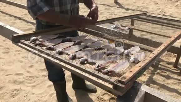 在大西洋沿岸的一个渔民村葡萄牙拿撒勒的海滩上渔民以传统的鱼干为生视频的预览图