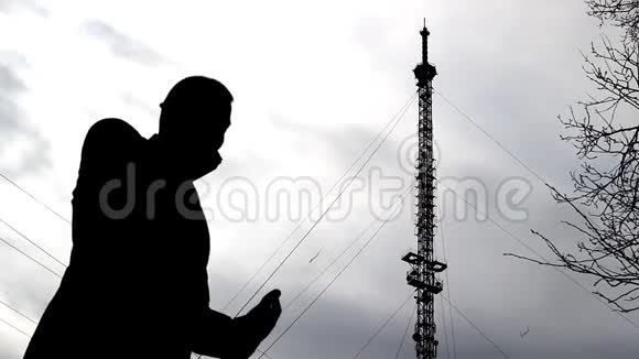 一个男人在电话塔的背景下打电话手机连接视频的预览图