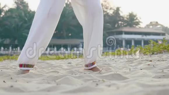 年长妇女在沙滩上练太极的近脚视频的预览图