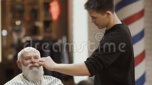 职业理发师梳成熟男人的胡须视频的预览图