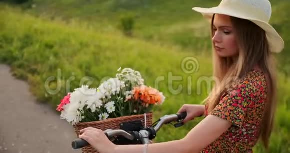 背部计划美丽的金发女郎穿着礼服复古自行车在夏天的田野上行走视频的预览图