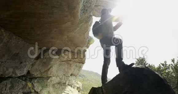 男子徒步旅行者在洞穴4k附近用手机拍照视频的预览图