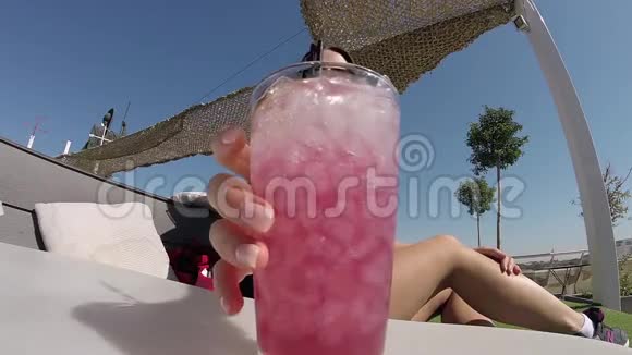 快乐的年轻女子在炎热的阳光日尽情畅饮冰凉的鸡尾酒视频的预览图