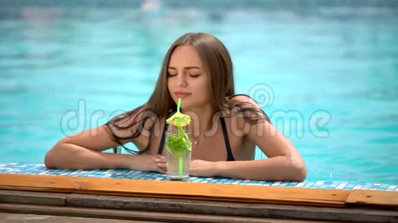 夏天美丽的年轻女子比基尼女孩在热带游泳池放松喝莫吉托鸡尾酒的女人视频的预览图