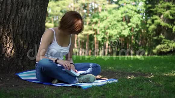 坐在公园里看书的女孩视频的预览图