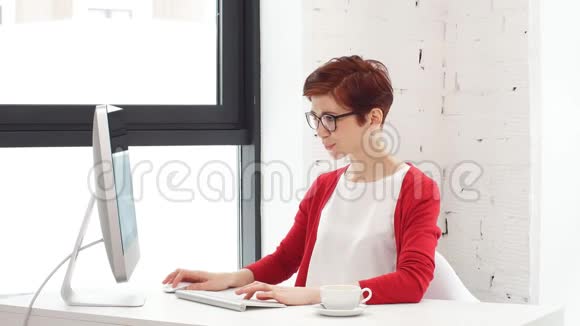 商务女性在明亮的办公室里敲键盘视频的预览图