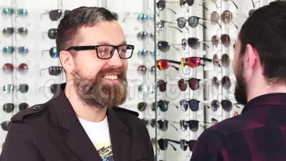 成熟男性顾客在选择新眼镜时与验光师交谈视频的预览图