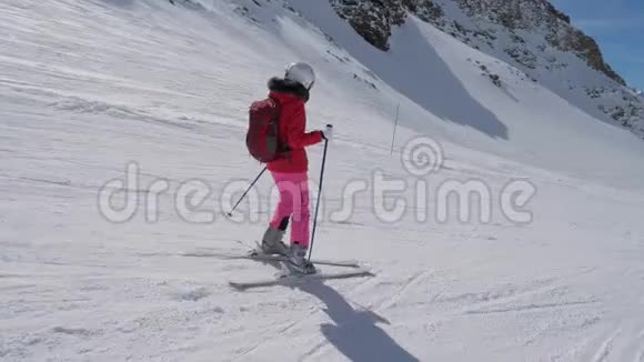 在运动侧景中女子滑雪者滑下山的度假村视频的预览图