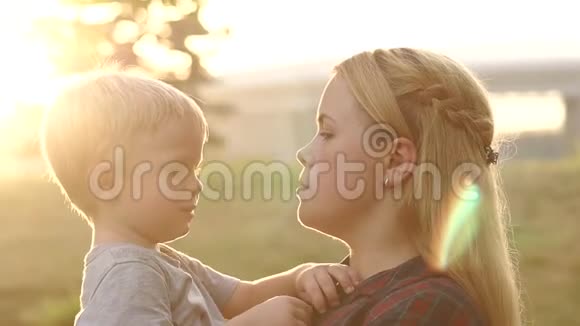 日落时分妈妈把她悲伤的儿子抱在公园里视频的预览图
