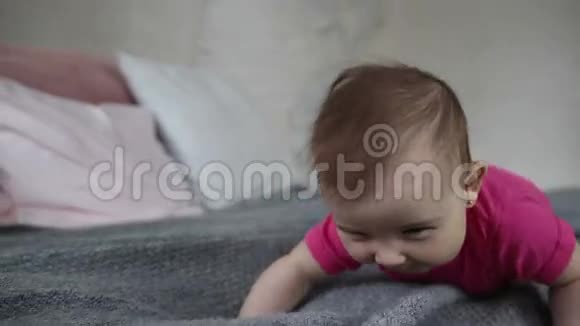 快乐的女婴在床上爬行视频的预览图