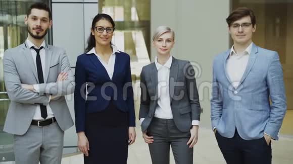 现代办公场所群商微笑的画像商人和女商人站在一起视频的预览图
