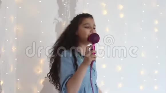 年轻女孩在吹风机里唱歌跳舞时心情很好家庭风格视频的预览图