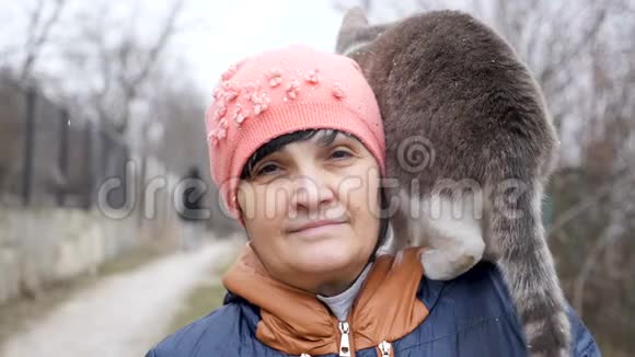 一个50多岁的女人肩上扛着一只猫对着镜头微笑视频的预览图