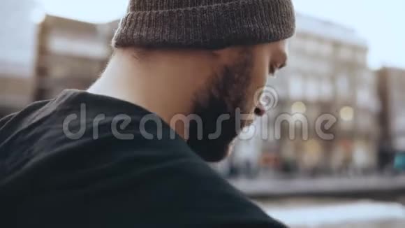 4K游客带智能手机在阿姆斯特丹行走最接近了戴帽子的男子沿着老城河堤散步视频的预览图