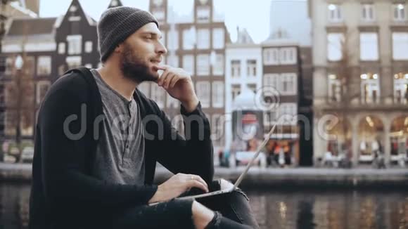 4K欧洲成年男子坐在外面的笔记本电脑受欢迎的在线博主在户外工作侧视生活方式拍摄视频的预览图