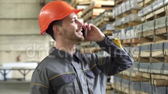 幸福的工厂工人在一个硬汉微笑着打电话视频的预览图
