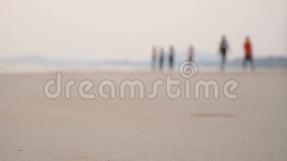 海滩上模糊的人和海浪的沙滩视频的预览图