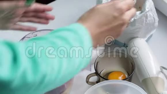 女人把面粉和鸡蛋和蔬菜加到搅拌机里视频的预览图