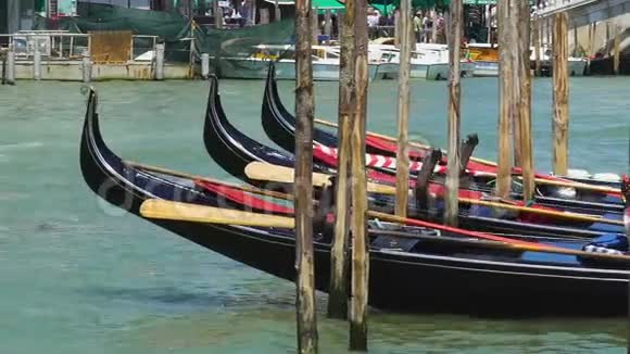 在码头上摇曳着装饰的贡多拉斯威尼斯的水上出租车作为旅游景点视频的预览图