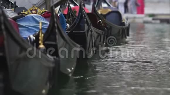 贡多拉斯连续停靠在水上摇摆为威尼斯游客提供复古出租车视频的预览图