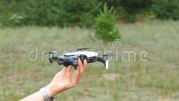一个人绿色森林的背景下手握一架无人机或四架直升机未来技术视频的预览图