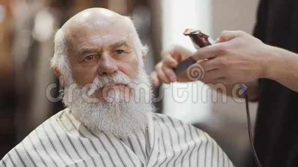 发型师用电动剃须刀为成熟男人做现代发型视频的预览图