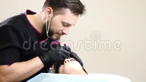 美容院男性美容师戴黑色手套在女性眉毛上做永久化妆程序微笑男视频的预览图