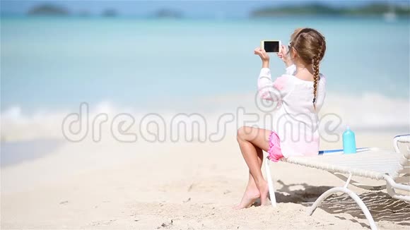 坐在躺椅上的小女孩用相机拍摄视频或照片视频的预览图