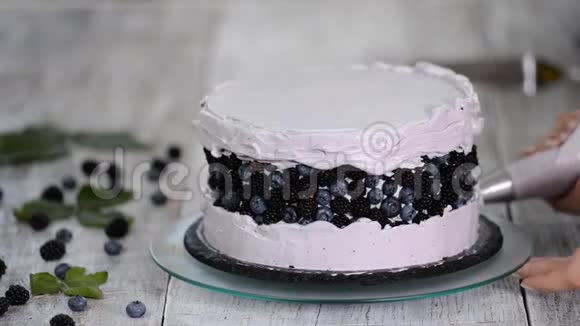 厨房里的糖果师用浆果奶油做一个海绵蛋糕自制糕点烹饪糕点的概念系列视频的预览图