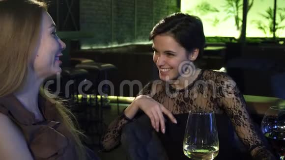 两个美丽开朗的女孩在酒吧边喝酒边笑视频的预览图