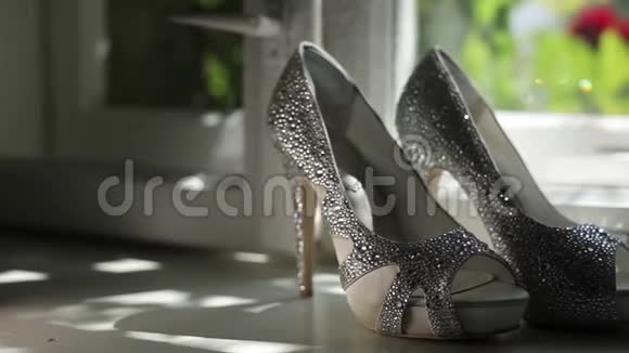 新娘婚礼的漂亮鞋子在莱茵石的白色窗户豪华跟头特写视频的预览图