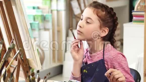 可爱的小女孩在美术课上画画时竖起大拇指视频的预览图