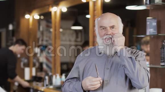 英俊的成熟男人扭着胡子在理发店摆姿势拍照视频的预览图