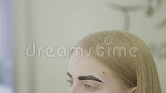美丽的年轻女孩在美容院等待眉毛油漆被吸收视频的预览图