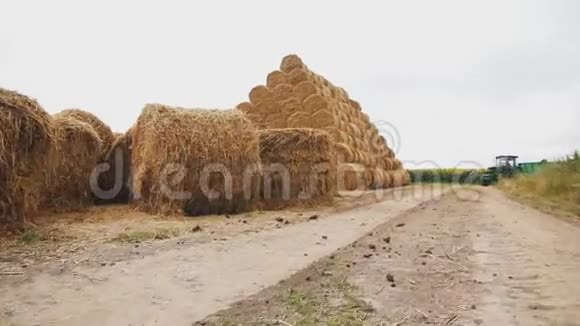 拖拉机在一捆捆的稻草附近行驶草包金字塔视频的预览图