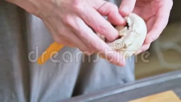在家庭厨房里厨师用女性的手把蘑菇的腿和白色蘑菇分开视频的预览图