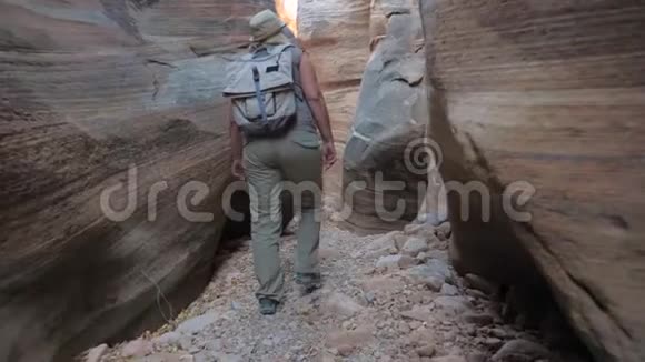 女子在干河峡谷徒步旅行峡谷4K的光滑和沉重的岩石视频的预览图