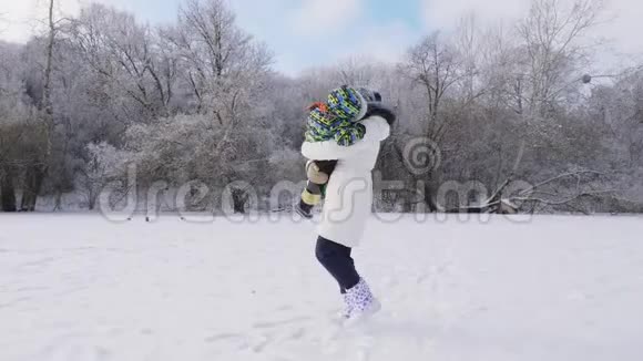 快乐的女人围着她的小儿子转冬天下雪视频的预览图