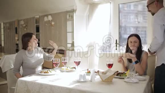 在餐馆见朋友快乐的朋友在餐馆吃喝四个朋友在餐厅吃饭视频的预览图