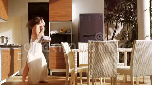 快乐的年轻女人在做早餐的时候在厨房里唱歌跳舞很有趣3840x2160视频的预览图