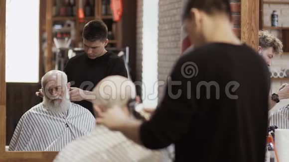 职业造型师用电动剃须刀给成熟的男人做新发型视频的预览图