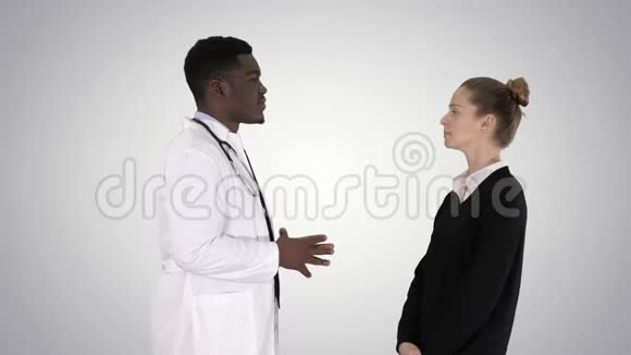 男性非洲医生在梯度背景下与女性患者交谈视频的预览图