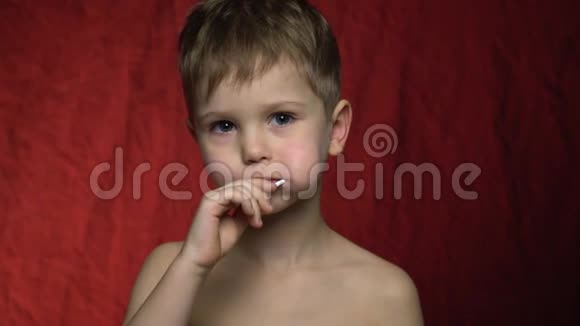 男孩吮吸糖果伸出拇指慢动作视频的预览图