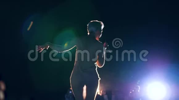 在室外音乐会上名人用麦克风在舞台上唱视频的预览图