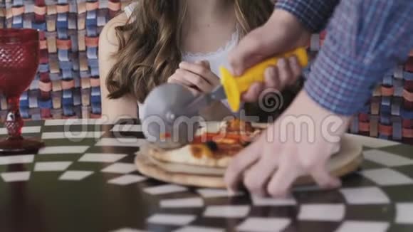 快乐的女孩看服务员如何在咖啡馆为她切披萨慢慢地视频的预览图