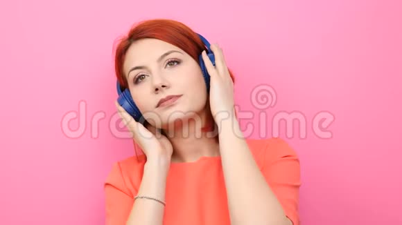 红头发的女人喜欢听耳机里的音乐视频的预览图