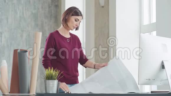 女人画着画在桌子上展开一张大纸视频的预览图