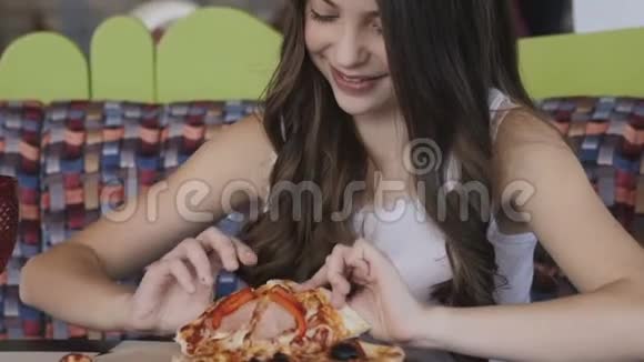 在咖啡馆里吃披萨的漂亮女孩的特写镜头视频的预览图