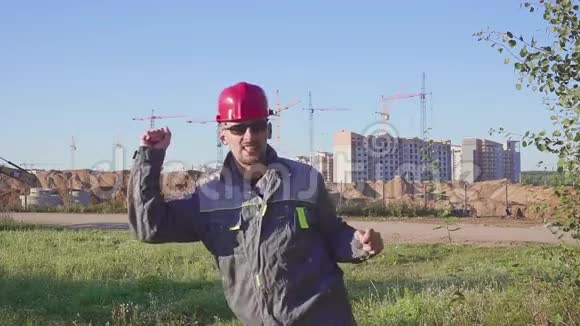 在施工现场工作后戴安全帽跳舞年轻工程师视频的预览图